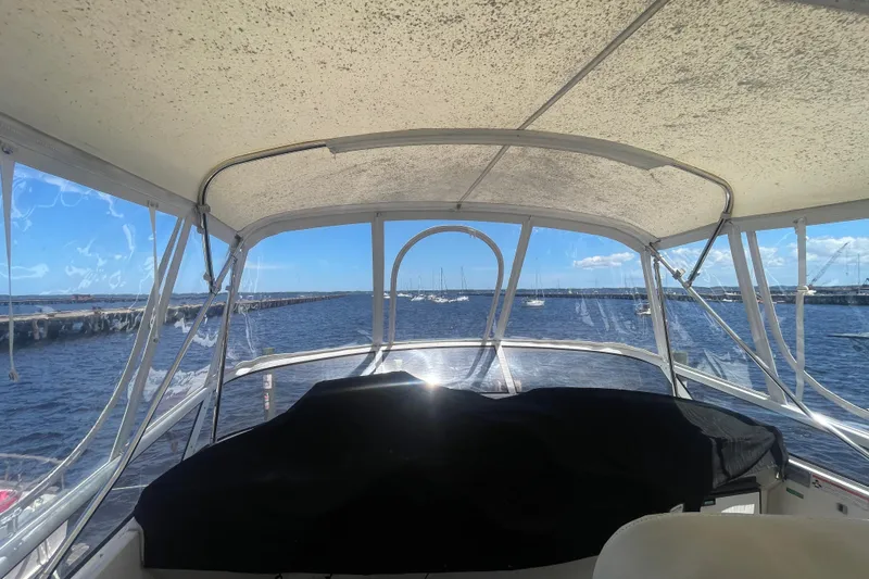 Slide: The Image of 2008 Carver 41 Cockpit Motor Yacht interior view with marina backdrop. - 15