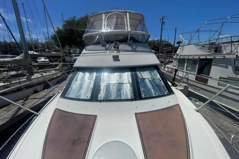 Slide: The Image of 2008 Carver 41 Cockpit Motor Yacht docked, featuring sunshade on windows under clear blue sky. - 16