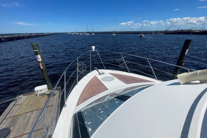 Slide: The Image of 2008 Carver 41 Cockpit Motor Yacht docked, overlooking a serene marina with sailboats. - 17