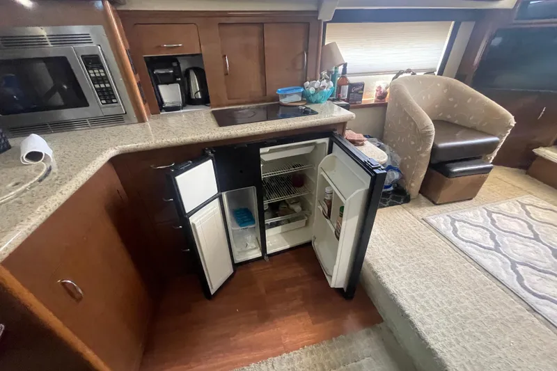 Slide: The Image of Interior of 2008 Carver 41 Cockpit Motor Yacht kitchen with open fridge and appliances. - 22