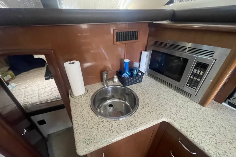 Slide: The Image of Compact kitchen area in 2008 Carver 41 Cockpit Motor Yacht with sink and microwave. - 23