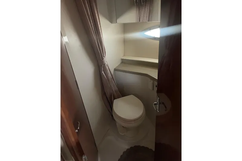 Slide: The Image of 2008 Carver 41 Cockpit Motor Yacht bathroom with toilet and small window. - 26