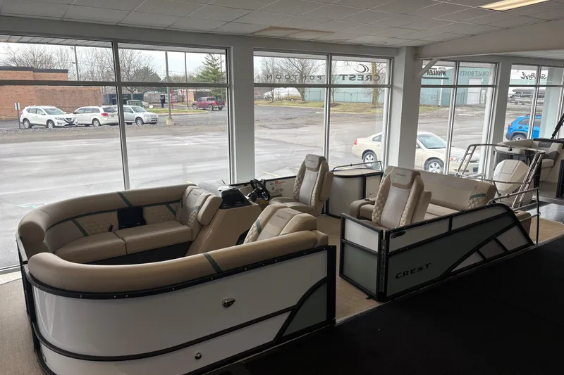 The Image of Interior view of a 2026 Crest 230SLC Conquest pontoon boat in showroom. - 1