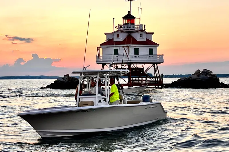 The Image of 2018 Sportsman Open 232 Center Console boat near a lighthouse at sunset. - 0