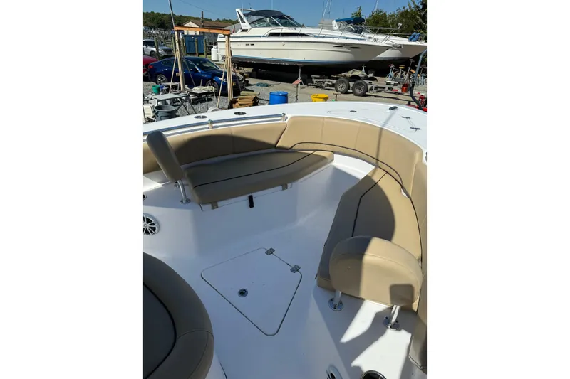 Slide: The Image of 2018 Sportsman Open 232 Center Console boat with tan seating in a marina setting. - 4