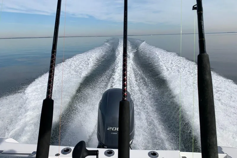 Slide: The Image of 2018 Sportsman Open 232 Center Console boat cruising on calm water, leaving a wake. - 8