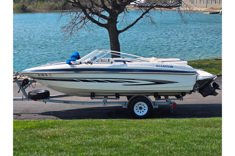 The Image of 2007 Glastron GT 185 boat on trailer by a lake. - 0