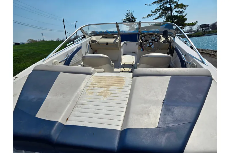 Slide: The Image of 2007 Glastron GT 185 boat interior with blue and white seating, steering wheel, and open deck. - 10