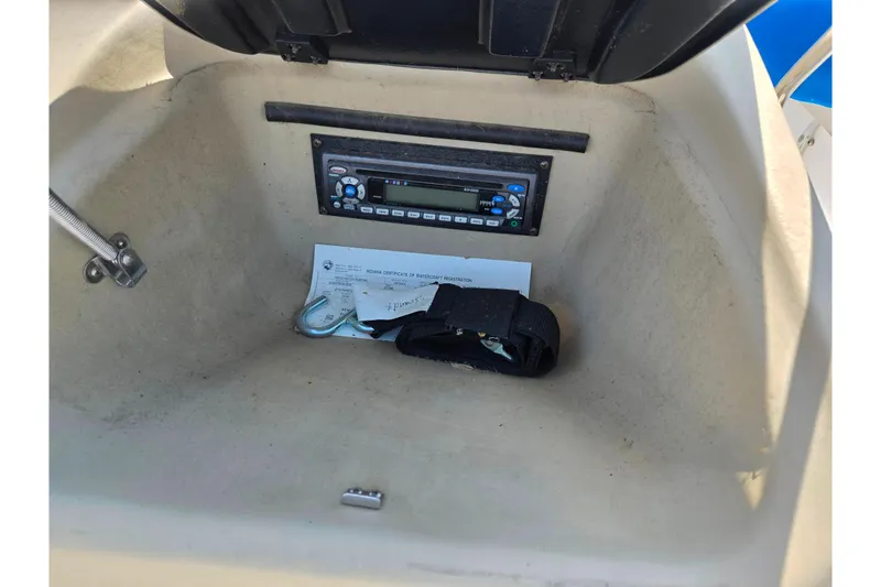 Slide: The Image of 2007 Glastron GT 185 boat storage compartment with stereo and documents. - 15