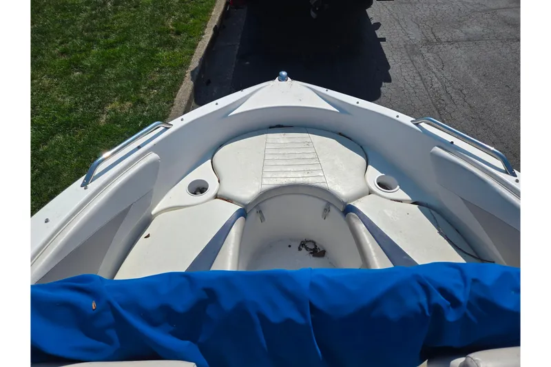 Slide: The Image of 2007 Glastron GT 185 boat interior with white seating and blue cover. - 17