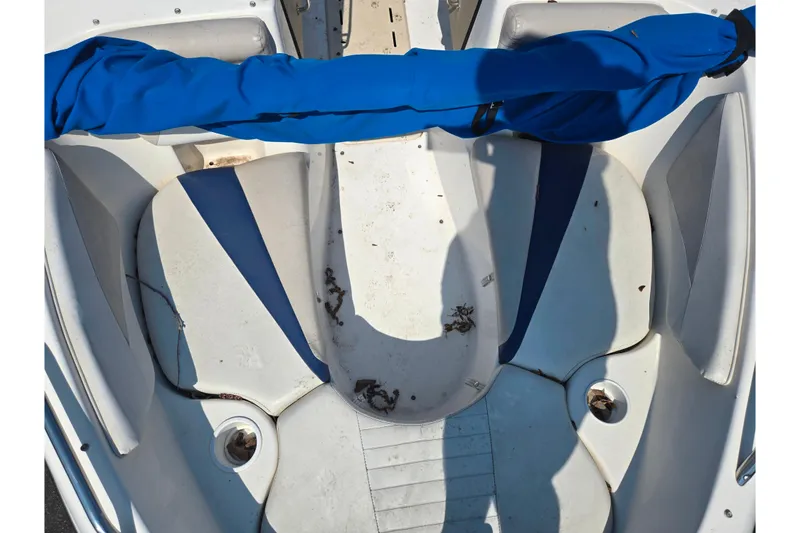 Slide: The Image of 2007 Glastron GT 185 boat interior with blue and white seating, showing some debris. - 19