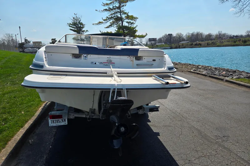Slide: The Image of 2007 Glastron GT 185 boat parked near a scenic lake. - 2