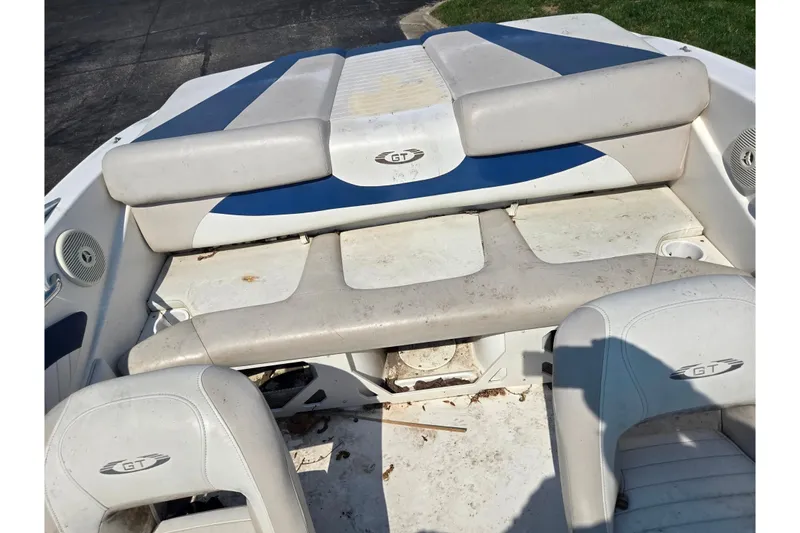 Slide: The Image of 2007 Glastron GT 185 boat interior with white and blue seating, showing wear. - 22