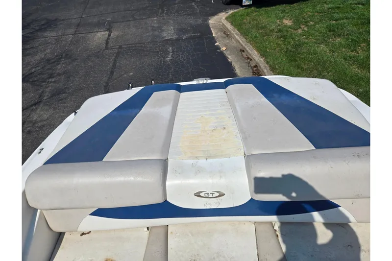 Slide: The Image of 2007 Glastron GT 185 boat with blue and white upholstery, parked on pavement. - 23