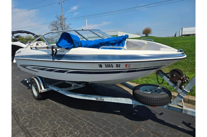 Slide: The Image of 2007 Glastron GT 185 boat on trailer, parked outdoors, with blue cover. - 5