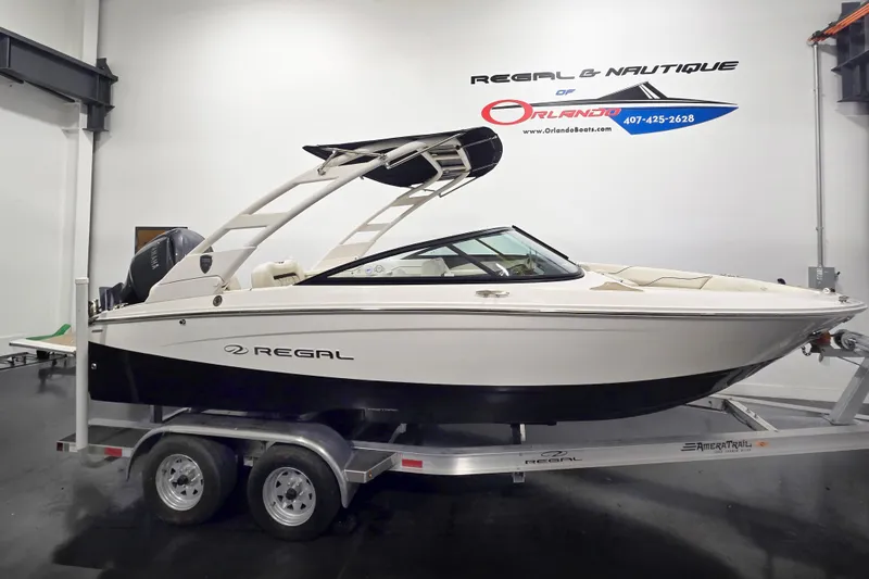 The Image of 2026 Regal LX2 boat on trailer in showroom, side view. - 0