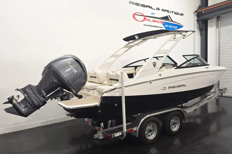 Slide: The Image of 2026 Regal LX2 boat on trailer with Yamaha outboard motor in showroom. - 2