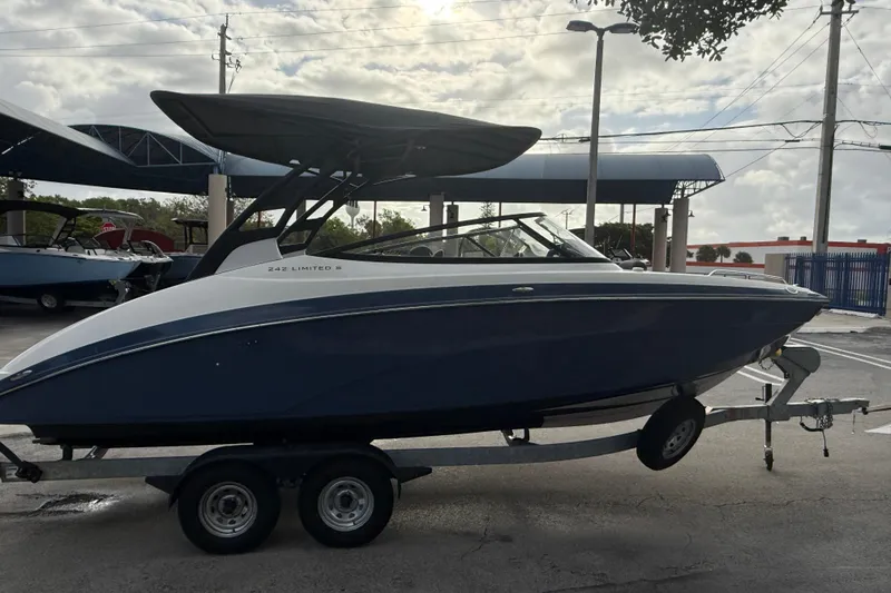 Slide: The Image of 2018 Yamaha Boats 242 Limited S E-Series on trailer, parked outdoors. - 11