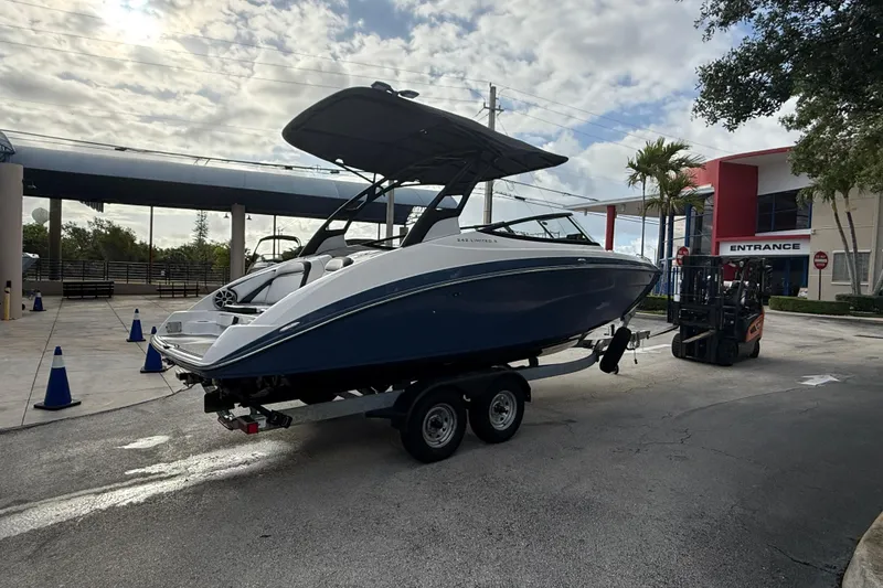 Slide: The Image of 2018 Yamaha Boats 242 Limited S E-Series on trailer at marina entrance. - 12