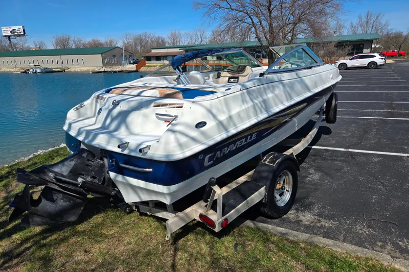 Slide: The Image of 2001 Caravelle 188 Bow Rider boat on trailer by a lake. - 1