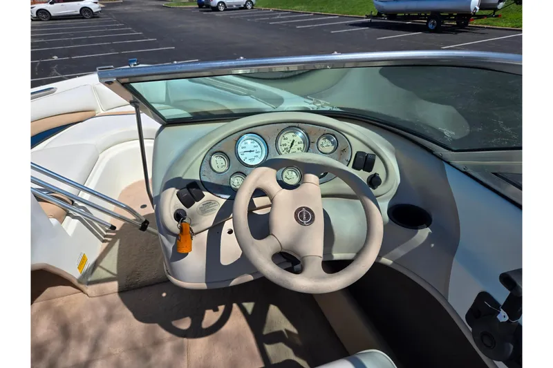Slide: The Image of 2001 Caravelle 188 Bow Rider dashboard with steering wheel and gauges in a parking lot. - 11