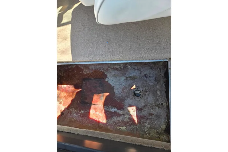 Slide: The Image of Interior view of a 2001 Caravelle 188 Bow Rider boat floor, showing wear and damage. - 12