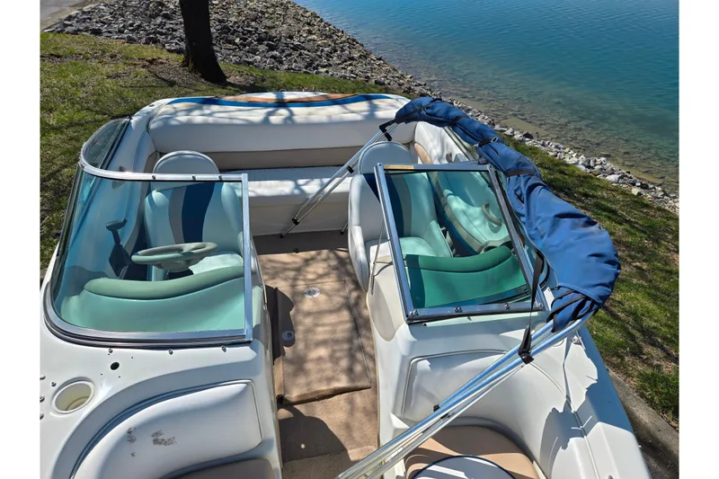 Slide: The Image of 2001 Caravelle 188 Bow Rider boat interior by a lakeside. - 17