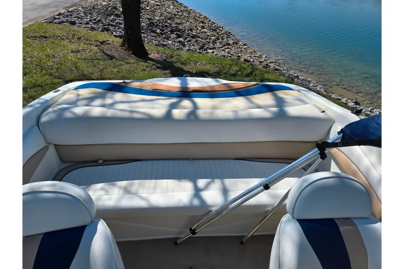 Slide: The Image of 2001 Caravelle 188 Bow Rider interior with white seating by a lakeside. - 19