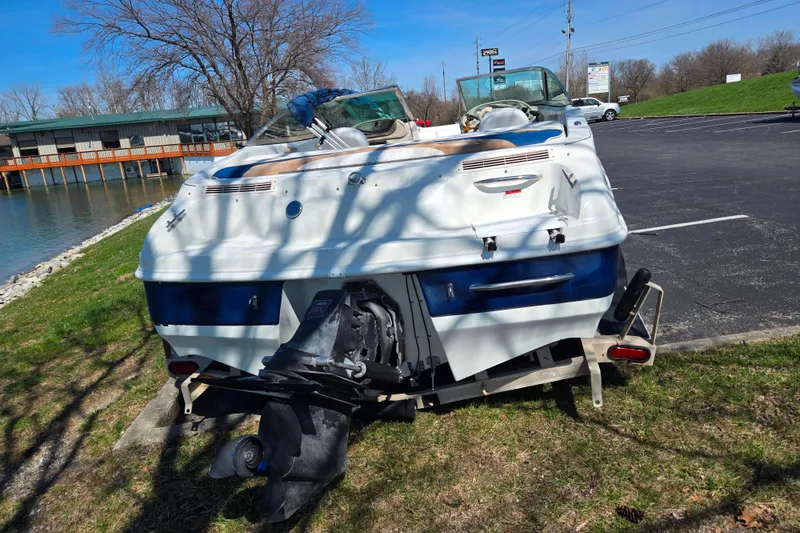 Slide: The Image of 2001 Caravelle 188 Bow Rider boat parked near a lake on a sunny day. - 2
