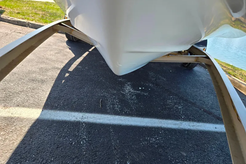 Slide: The Image of 2001 Caravelle 188 Bow Rider boat on trailer, parked on asphalt near water. - 7