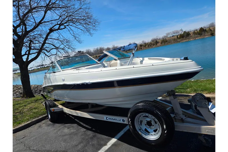 Slide: The Image of 2001 Caravelle 188 Bow Rider boat on trailer by a lake. - 8