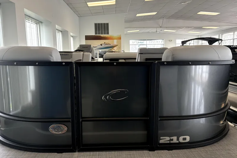 Slide: The Image of 2026 Crest 210L Conquest pontoon boat interior in showroom setting. - 2