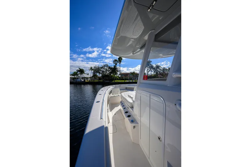 Slide: The Image of 2021 Invincible 39 Open Fisherman boat, sleek design, docked under clear blue sky. - 28