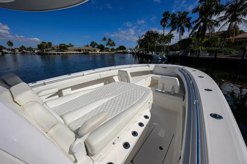 Slide: The Image of 2021 Invincible 39 Open Fisherman boat with luxurious seating, docked by palm trees. - 44