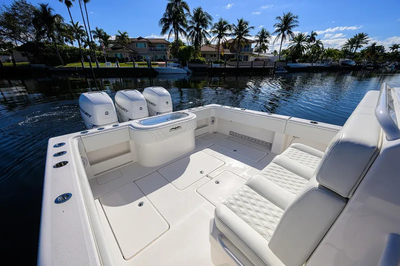 Slide: The Image of 2021 Invincible 39 Open Fisherman boat with triple Mercury engines, docked by palm trees. - 47