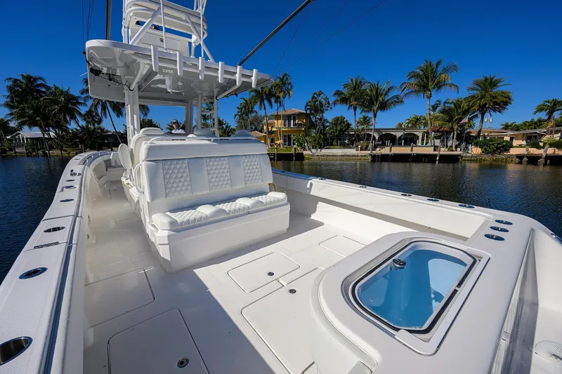 Slide: The Image of 2021 Invincible 39 Open Fisherman boat on a sunny day, docked near palm trees. - 53