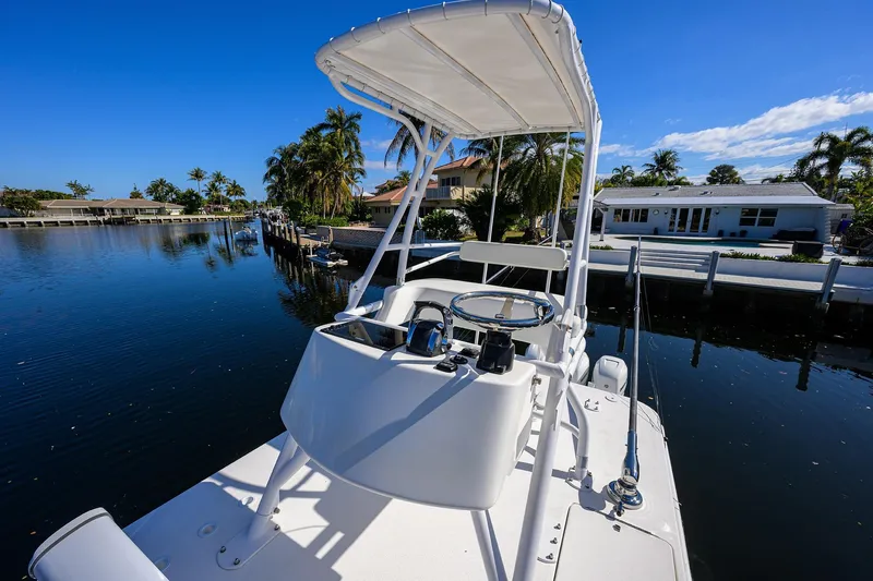 Slide: The Image of 2021 Invincible 39 Open Fisherman boat docked by waterfront homes, under clear blue sky. - 78