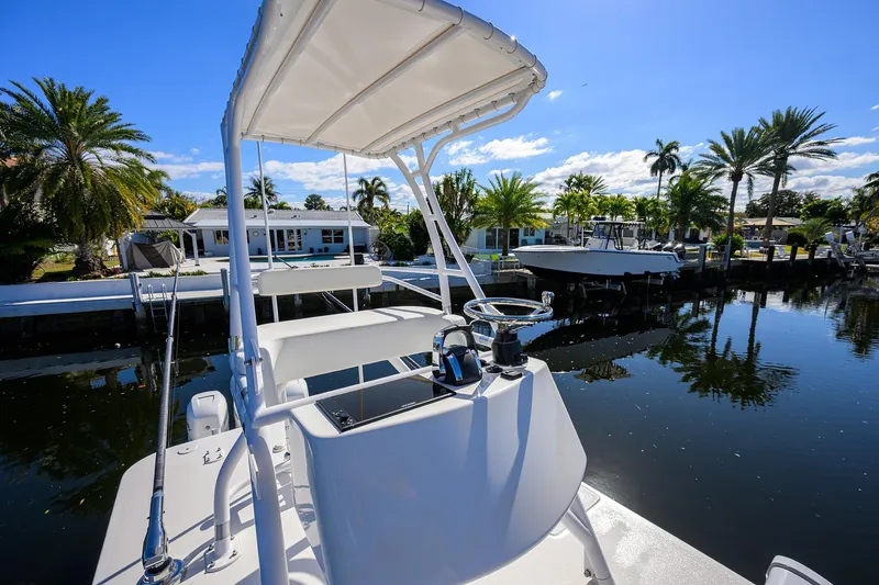 Slide: The Image of 2021 Invincible 39 Open Fisherman boat docked near palm trees and waterfront homes. - 81