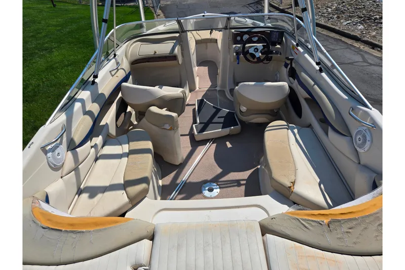 Slide: The Image of 2005 Glastron GX 235 boat interior with beige seating and steering console. - 11