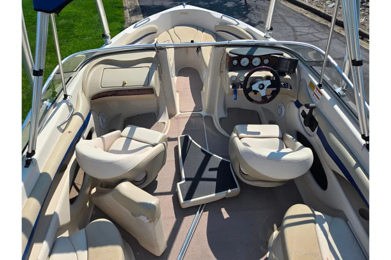 Slide: The Image of 2005 Glastron GX 235 boat interior with beige seating and steering console. - 12