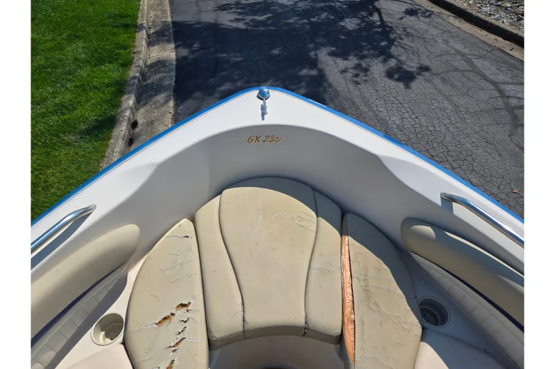 Slide: The Image of 2005 Glastron GX 235 boat interior with worn beige seating and visible model name. - 18
