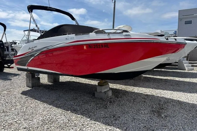 The Image of 2020 Hurricane SunDeck 191 OB boat with red hull on display outdoors. - 0