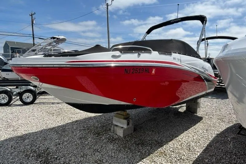Slide: The Image of 2020 Hurricane SunDeck 191 OB boat in vibrant red, displayed on blocks outdoors. - 1