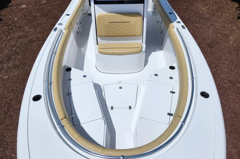 Slide: The Image of 2024 Sportsman Open 232 Center Console boat with tan seating and storage compartments. - 10