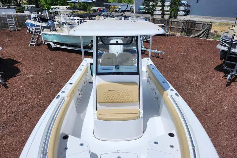 Slide: The Image of 2024 Sportsman Open 232 Center Console boat with beige seating, displayed outdoors. - 11