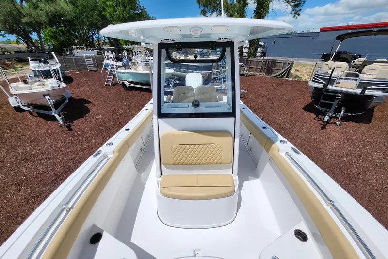 Slide: The Image of 2024 Sportsman Open 232 Center Console boat with tan seating, displayed outdoors. - 14