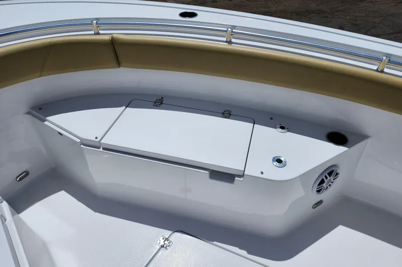 Slide: The Image of 2024 Sportsman Open 232 Center Console boat interior with cushioned seating and storage compartment. - 18