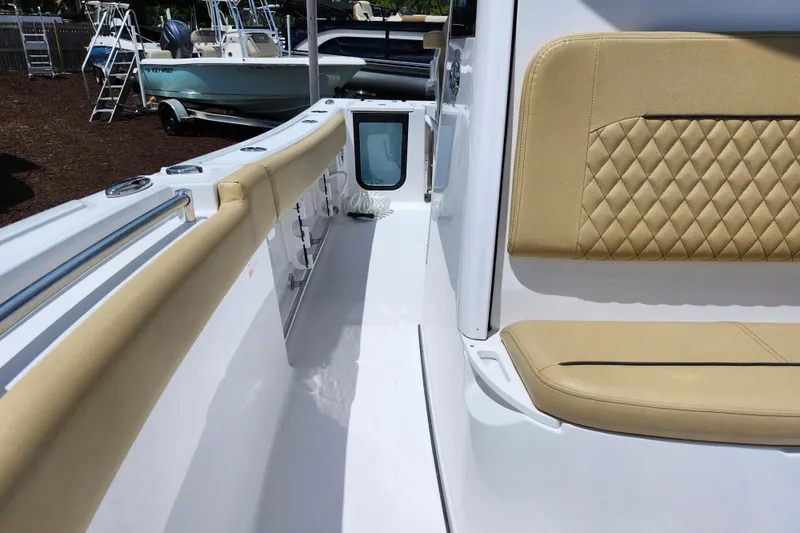 Slide: The Image of 2024 Sportsman Open 232 Center Console boat interior with tan seating and white deck. - 21