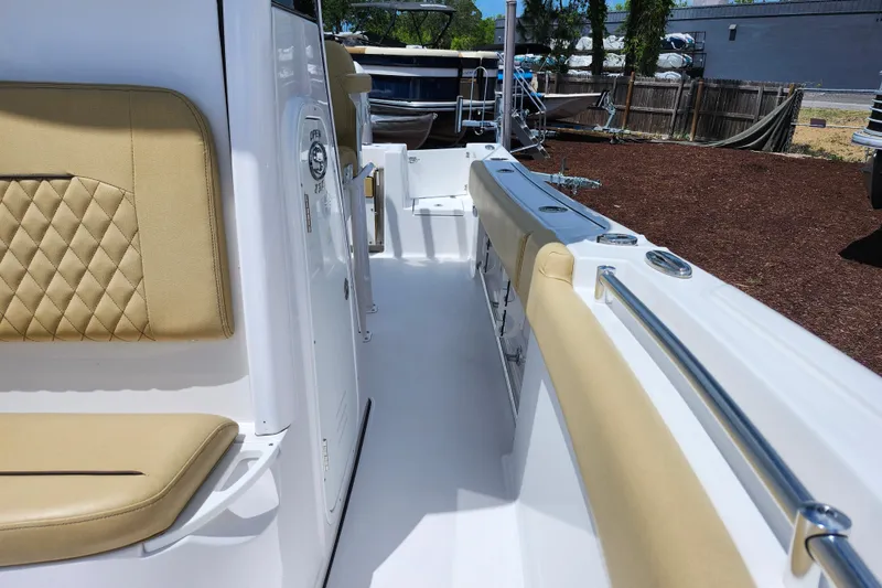 Slide: The Image of 2024 Sportsman Open 232 Center Console boat interior with tan seating and sleek design. - 22