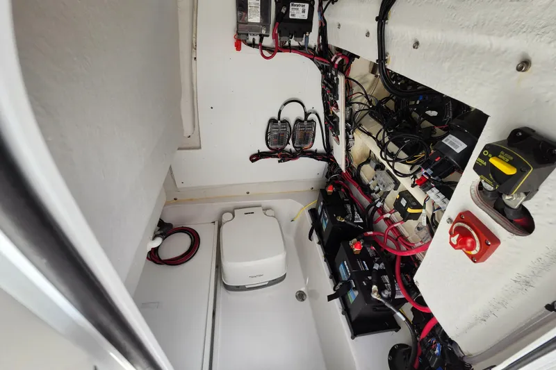 Slide: The Image of 2024 Sportsman Open 232 Center Console electrical compartment with wiring and battery setup. - 25